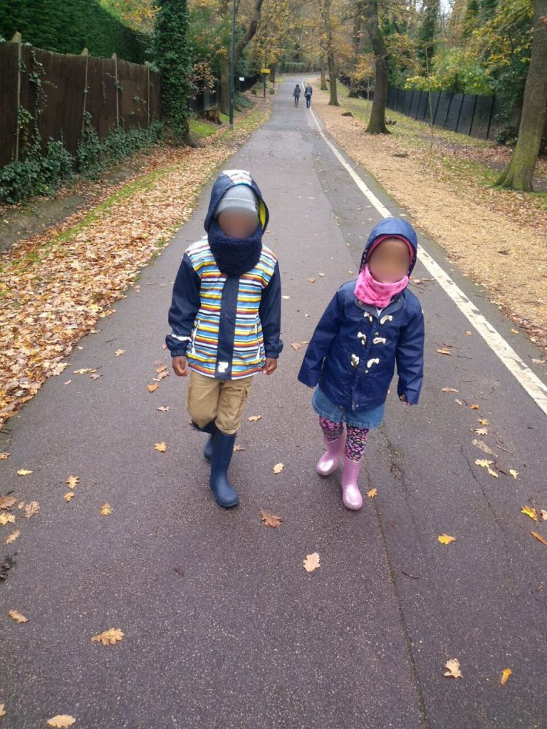 Yvonne's children on the street walking with their coats on.