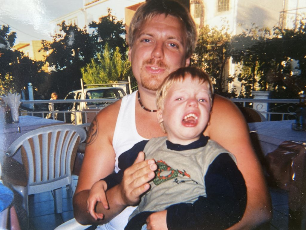 My son before the autism turnaround, sitting on his father's lap, crying 